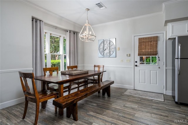 dining room with a notable chandelier, visible vents, baseboards, ornamental molding, and dark wood finished floors