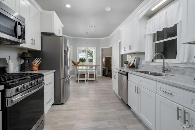 2603 Lauren St, Northport, AL 35475 - kitchen featuring stainless steel appliances, a sink, white cabinetry, baseboards, and ornamental molding