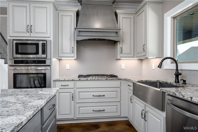 12030 Orlea Ln, Northport, AL 35475 - kitchen featuring appliances with stainless steel finishes, custom exhaust hood, a sink, light stone counters, and white cabinets