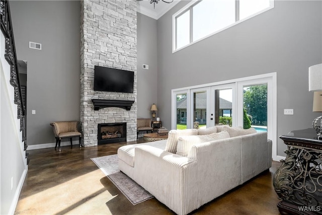 12030 Orlea Ln, Northport, AL 35475 - living area with a towering ceiling, a stone fireplace, baseboards, french doors, and ornamental molding