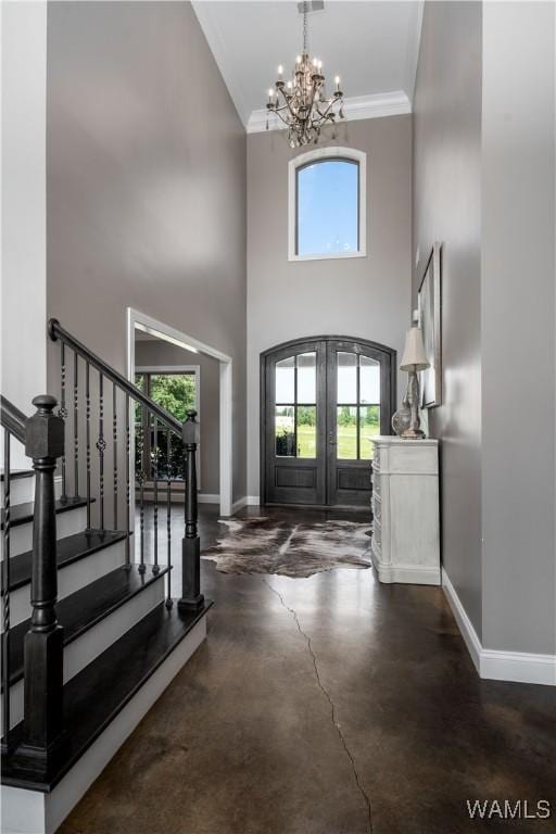 12030 Orlea Ln, Northport, AL 35475 - foyer entrance featuring french doors, a chandelier, baseboards, a high ceiling, and crown molding