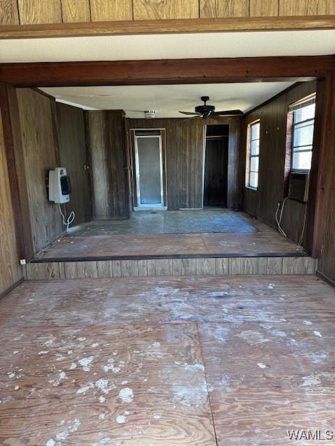 interior space featuring wooden walls and ceiling fan