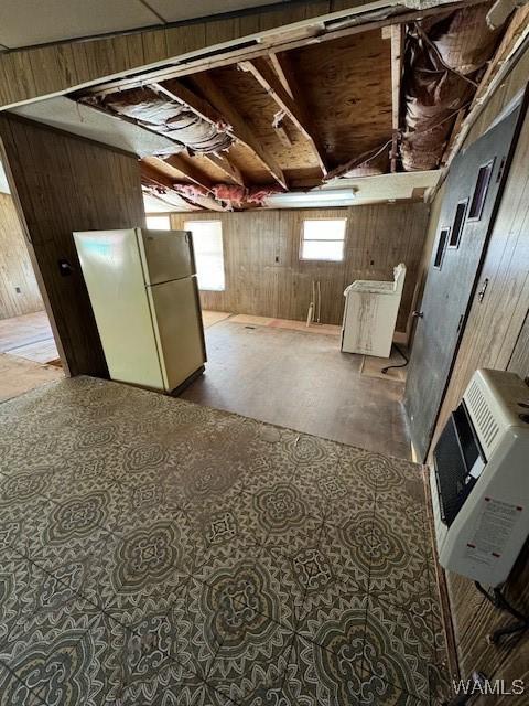 basement featuring heating unit and refrigerator