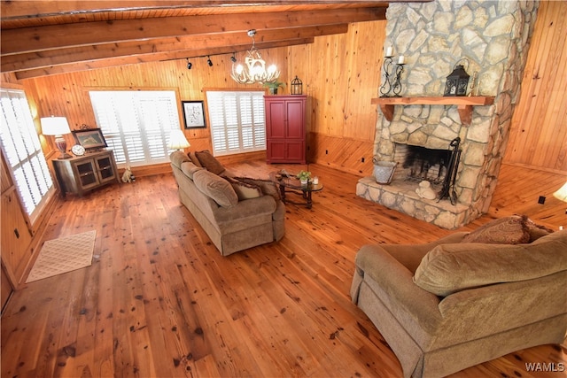 living room featuring an inviting chandelier, vaulted ceiling with beams, wooden walls, a fireplace, and hardwood / wood-style flooring