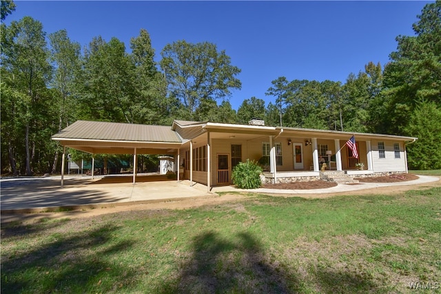 view of front of house with a carport, a porch, and a front lawn