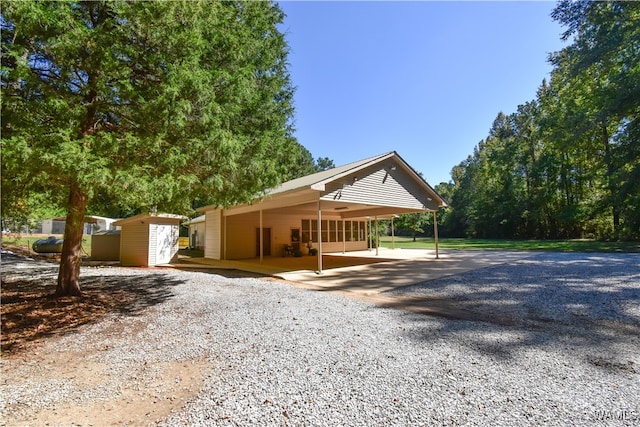 view of front of house with a storage unit and a carport