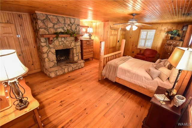 bedroom featuring light wood-type flooring, wooden walls, and wooden ceiling