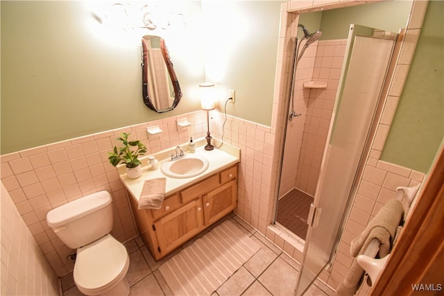 bathroom with walk in shower, tile patterned flooring, toilet, vanity, and tile walls