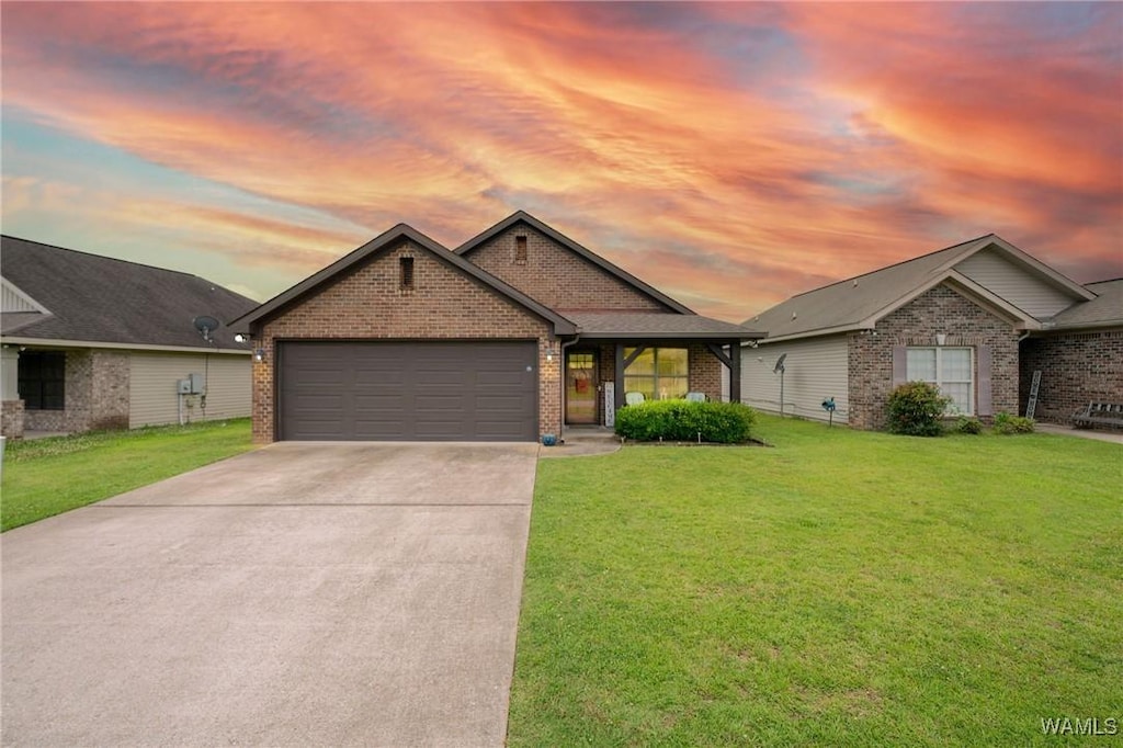 12962 Garden Creek Ln, Northport, AL 35473 - view of front facade featuring brick siding, a front yard, concrete driveway, and an attached garage
