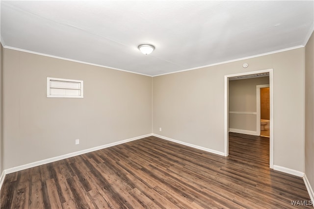 empty room featuring dark hardwood / wood-style flooring and ornamental molding