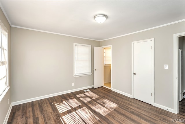 unfurnished bedroom with dark hardwood / wood-style flooring, ornamental molding, and a closet