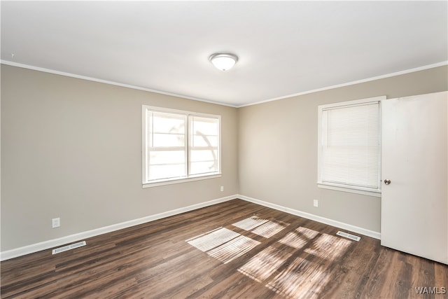 spare room featuring dark hardwood / wood-style flooring and ornamental molding