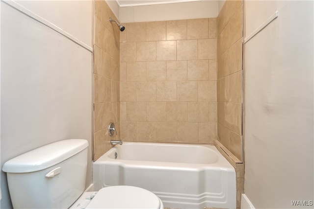 bathroom with toilet and tiled shower / bath