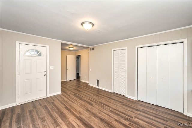 entryway with dark hardwood / wood-style floors and crown molding