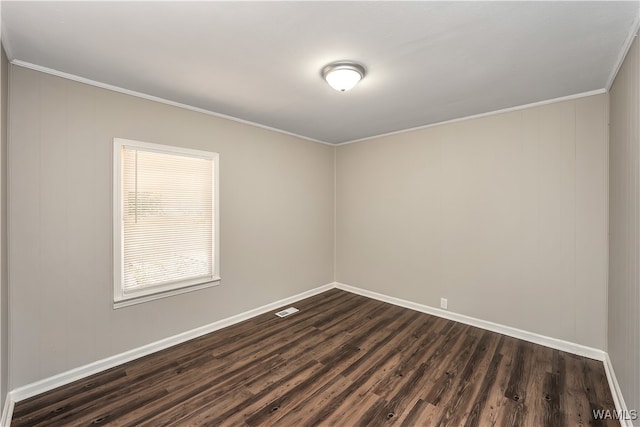 empty room featuring crown molding and dark hardwood / wood-style flooring