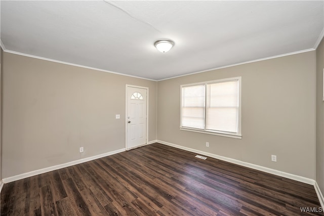 spare room featuring dark hardwood / wood-style floors and crown molding