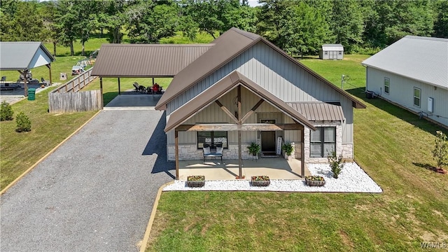 12625 Northside Rd, Northport, AL 35475 - rear view of house featuring stone siding, a lawn, a carport, driveway, and board and batten siding