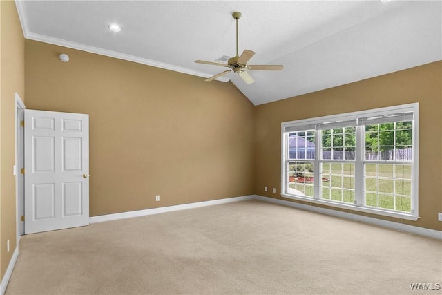 empty room with lofted ceiling, a ceiling fan, crown molding, baseboards, and light colored carpet