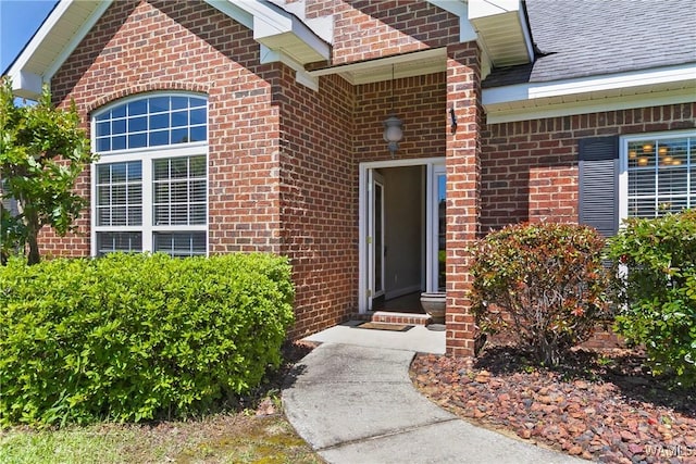 property entrance with brick siding and a shingled roof