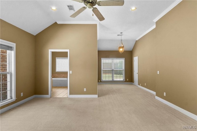 spare room with visible vents, light colored carpet, baseboards, and vaulted ceiling