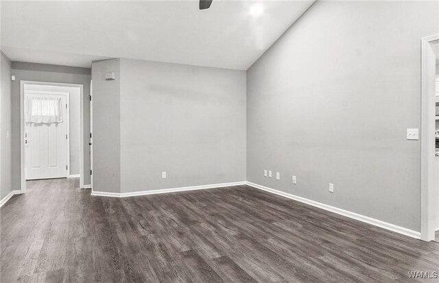 empty room with ceiling fan, dark wood-type flooring, and vaulted ceiling