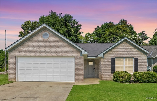 single story home featuring a garage, brick siding, a yard, and driveway