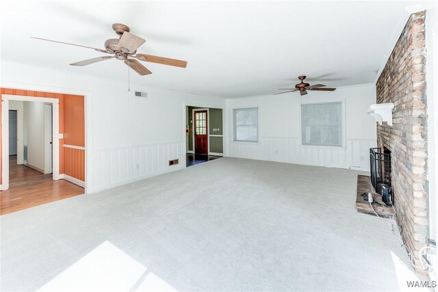 9C Country Club Hls, Tuscaloosa, AL 35401 - unfurnished living room featuring a ceiling fan, carpet floors, wainscoting, and a brick fireplace
