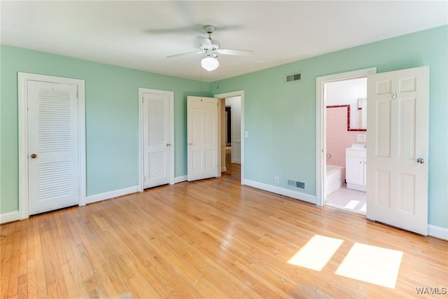 9C Country Club Hls, Tuscaloosa, AL 35401 - unfurnished bedroom featuring light wood finished floors, multiple closets, baseboards, and ensuite bathroom