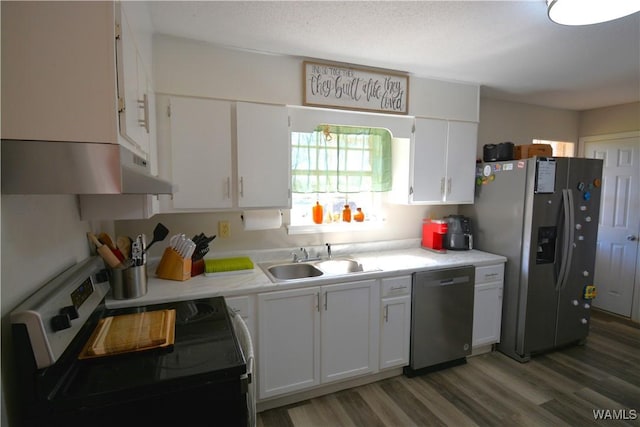 kitchen with stainless steel appliances, a sink, and white cabinets