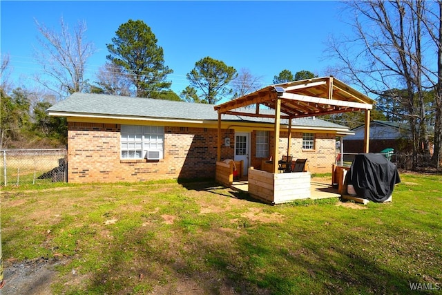 rear view of house with a yard, cooling unit, brick siding, and fence