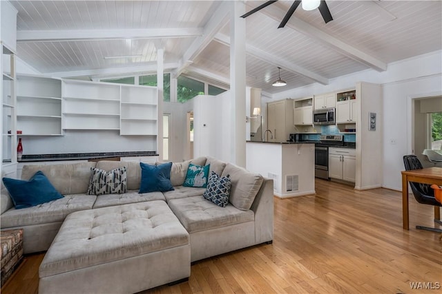 living room featuring sink, light hardwood / wood-style flooring, lofted ceiling with beams, and a healthy amount of sunlight