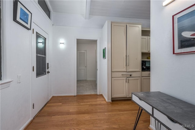 corridor with light hardwood / wood-style flooring and beamed ceiling