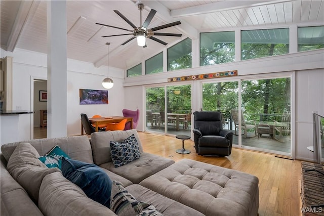 living room with high vaulted ceiling, hardwood / wood-style floors, and beamed ceiling