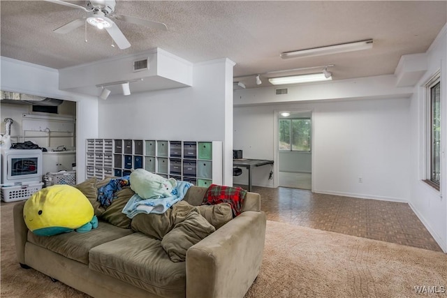 living room with ceiling fan, a textured ceiling, ornamental molding, and mail boxes