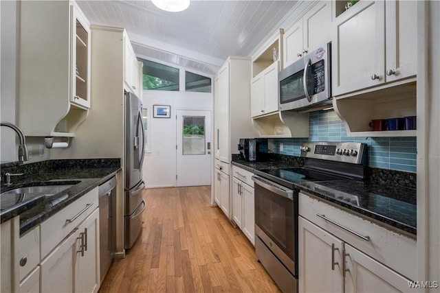 kitchen with wood ceiling, white cabinetry, sink, dark stone countertops, and stainless steel appliances