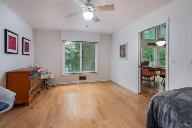 bedroom with light hardwood / wood-style floors, ornamental molding, and ceiling fan