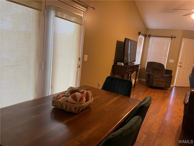 dining room with hardwood / wood-style flooring, ceiling fan, and lofted ceiling