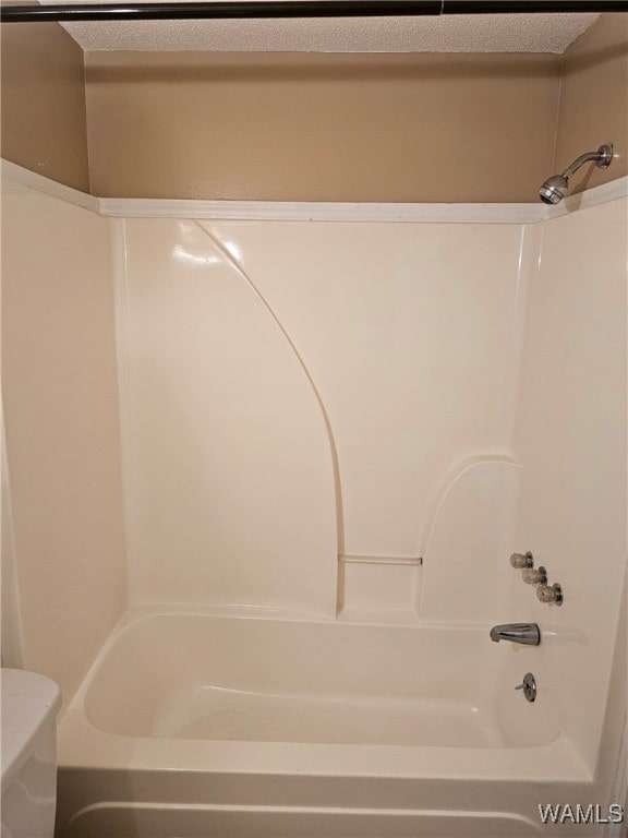 bathroom featuring a textured ceiling, toilet, and shower / bathtub combination