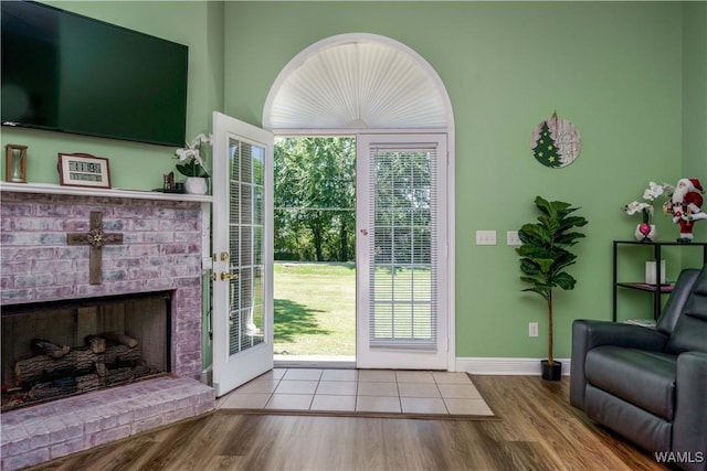 6650 Flatwoods Rd, Northport, AL 35473 - doorway featuring wood finished floors, a brick fireplace, and baseboards