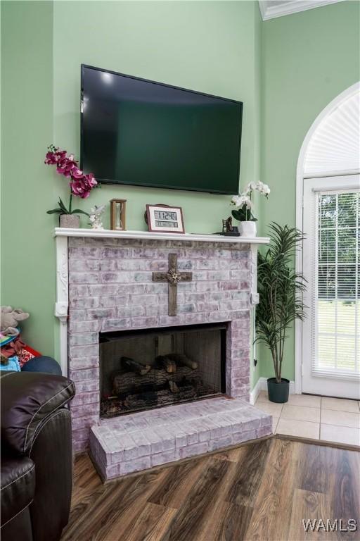 6650 Flatwoods Rd, Northport, AL 35473 - living room featuring a brick fireplace, wood finished floors, and ornamental molding