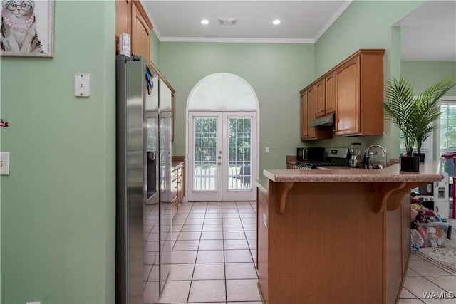 6650 Flatwoods Rd, Northport, AL 35473 - kitchen featuring french doors, appliances with stainless steel finishes, light tile patterned flooring, a breakfast bar area, and a peninsula