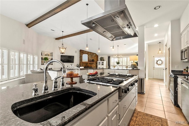 kitchen featuring sink, white cabinetry, appliances with stainless steel finishes, island exhaust hood, and beam ceiling