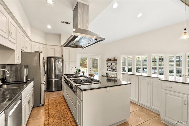 kitchen with light tile patterned floors, stainless steel appliances, white cabinets, and island exhaust hood