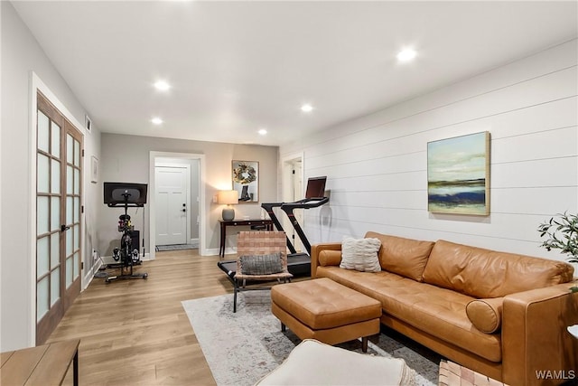 living room featuring light hardwood / wood-style floors and wood walls