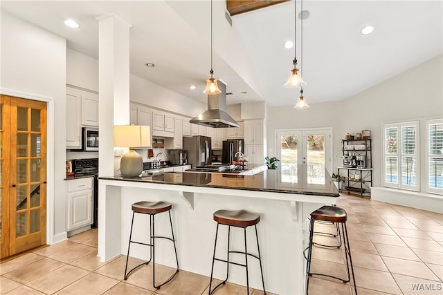 kitchen with french doors, a breakfast bar, vaulted ceiling, and white cabinets