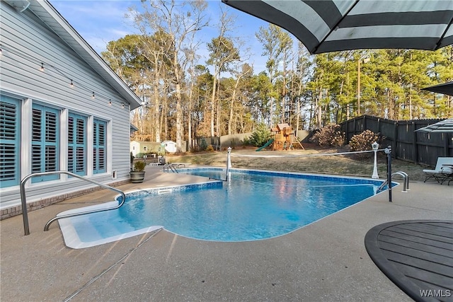 view of swimming pool featuring a patio area and a playground