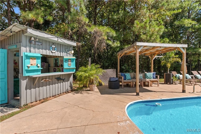 view of pool with outdoor lounge area, an outbuilding, and a patio area