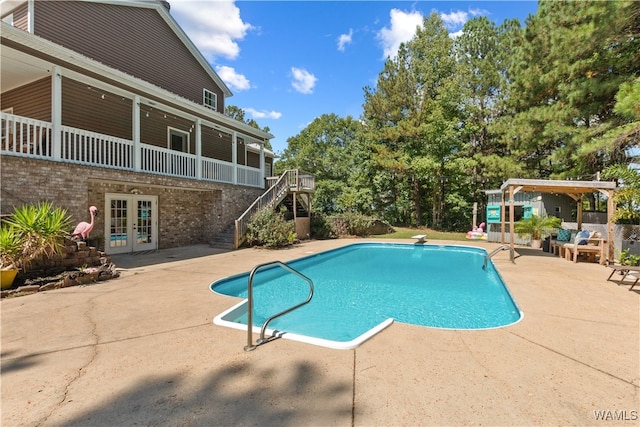 view of swimming pool with french doors and a patio