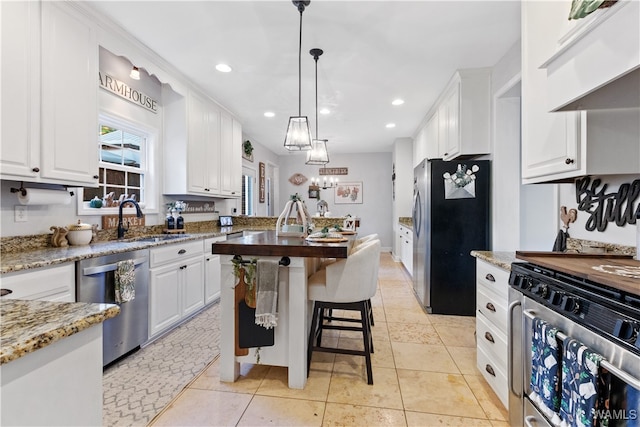 kitchen with white cabinets, pendant lighting, sink, and stainless steel appliances