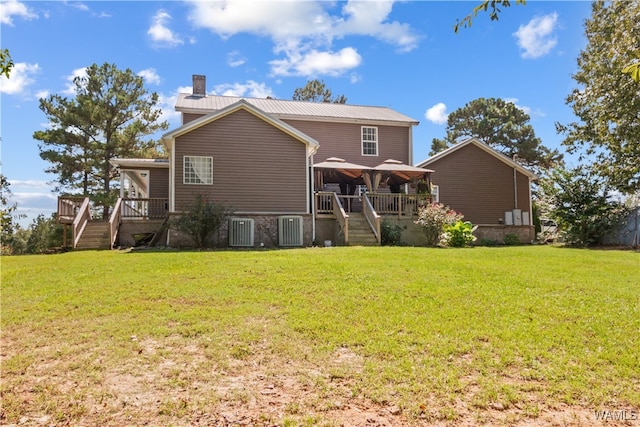 rear view of property featuring cooling unit and a lawn